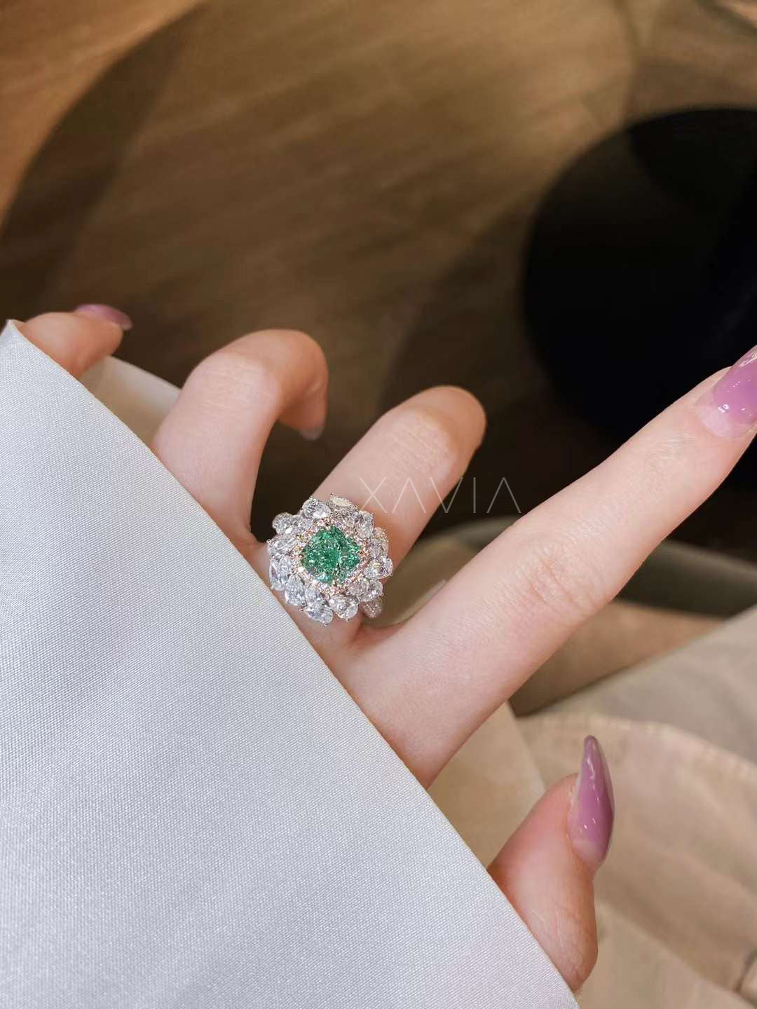 green cushion diamond ring with pear cluster halo worn on finger showcasing bold cocktail styling